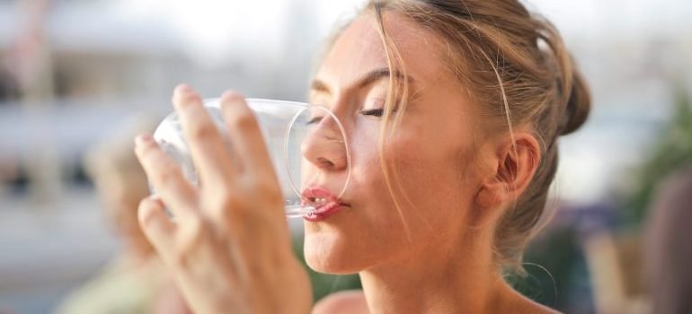 Žena koja pije vodu iz čaše.