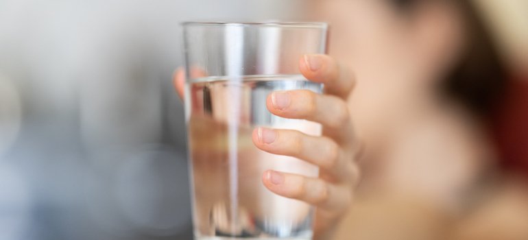 Osoba drži čašu punu vode.