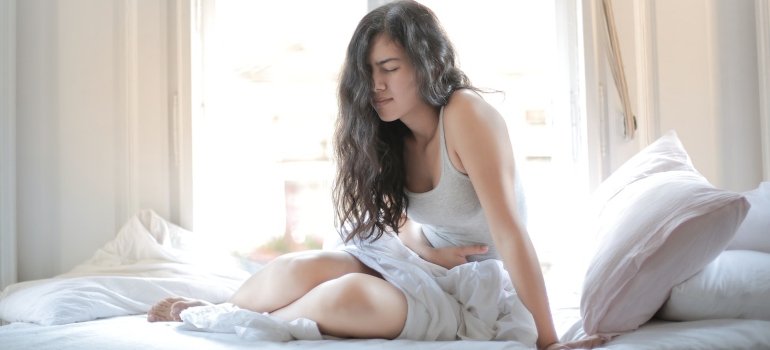 Žena koju boli stomak jer ima helikobakter pilori.