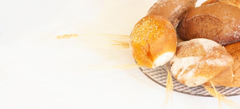 Hleb i pecivo od belog brašna na tacni.