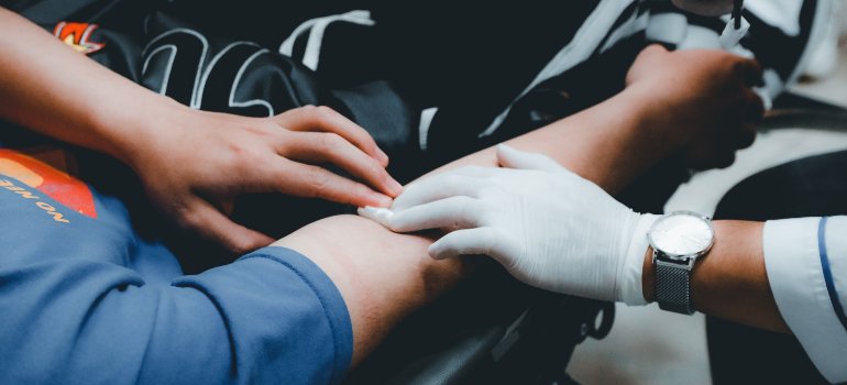 Laboratorijski tehničar vadi krvi pacijentu kako bi se objasni uticaj infekcija na krvnu sliku.