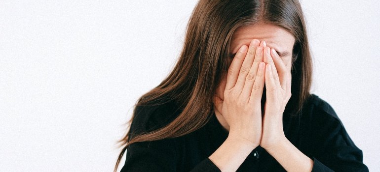 Žena koja se drži za glavu zbog stresa