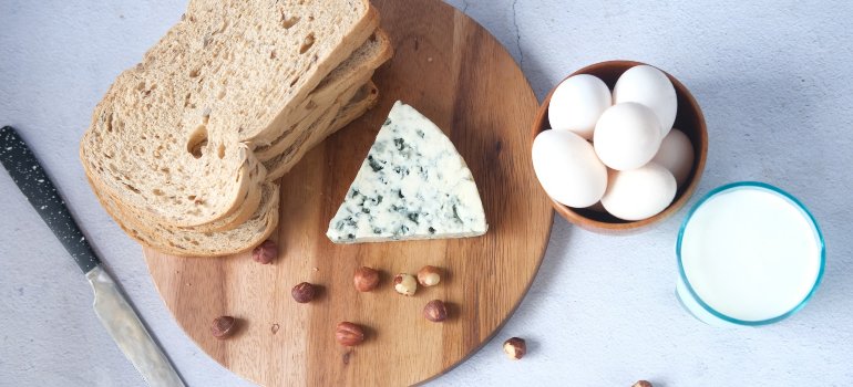 Hrana na stolu, uključujući hleb, sir, jaja i mleko.