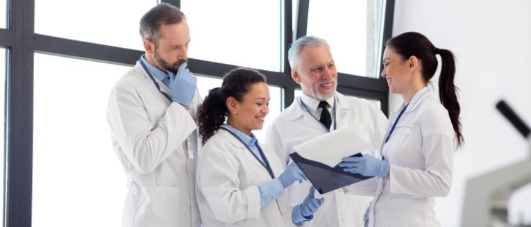 Medical lab technicians are engaged in a discussion about hematological tests.