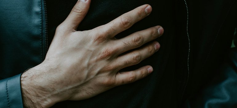 Muškarac koji drži ruku na grudima