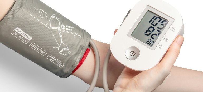 Osoba koristi digitalni merač da izmeri pritisak.