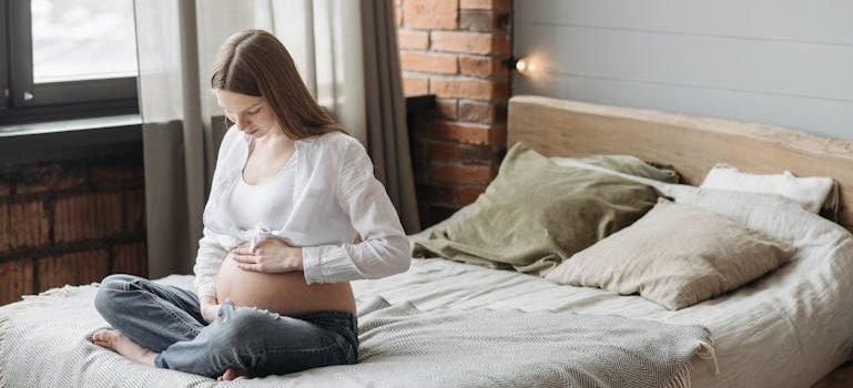Беременная женщина сидит на кровати