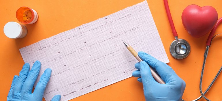 Врач что-то пишет по результатам ЭКГ.