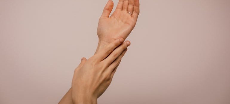 Ruke koje se drže za zglob, prikazujući osećaj bola ili nelagodnosti.
