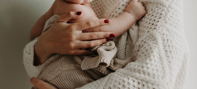 A mother holding her baby in her arms.