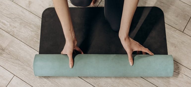 A woman unrolling a yoga mat.