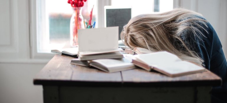 Женщина спит, положив голову на стол из-за усталости.