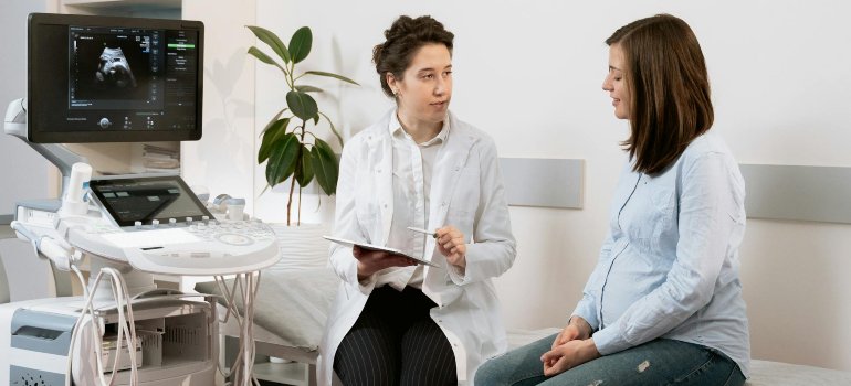 Беременная женщина обсуждает с гинекологом повышенный уровень сахара в моче у беременных.