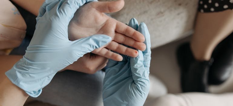 A lab technician collecting a small blood sample from the fingertip for the MxA/CRP test