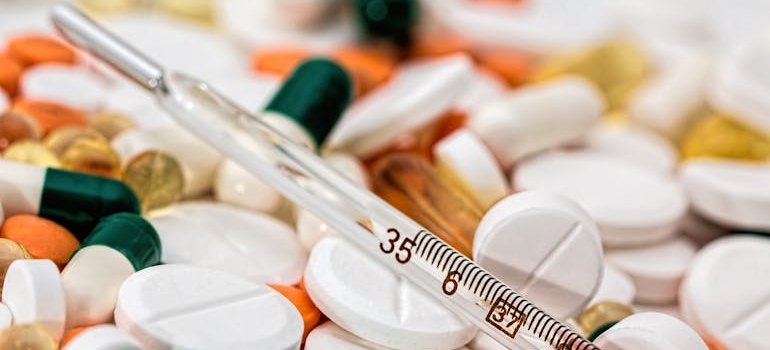 A thermometer and medications used to treat mononucleosis