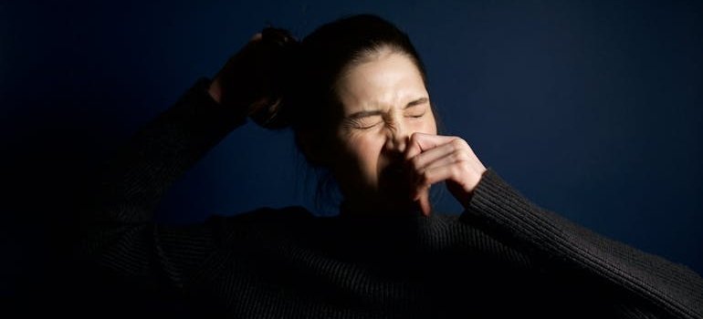 Женщина чихает