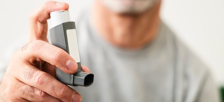 человек который знает что такое аллергическая астма держит ингалятор