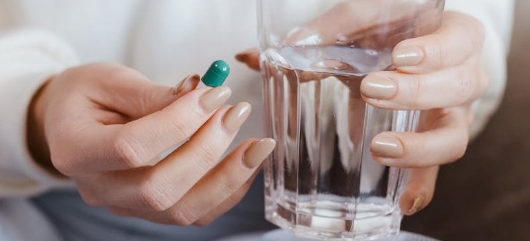 Человек держит лекарство, которое помогает при воспалении толстого кишечника