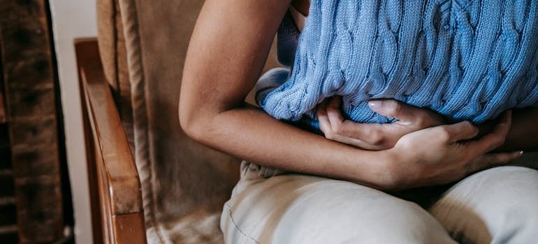 Женщина с болью в животе думает, что причиной может быть воспаление толстого кишечника