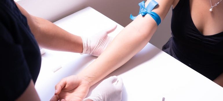 Врач берёт кровь, чтобы определить группу крови пациента