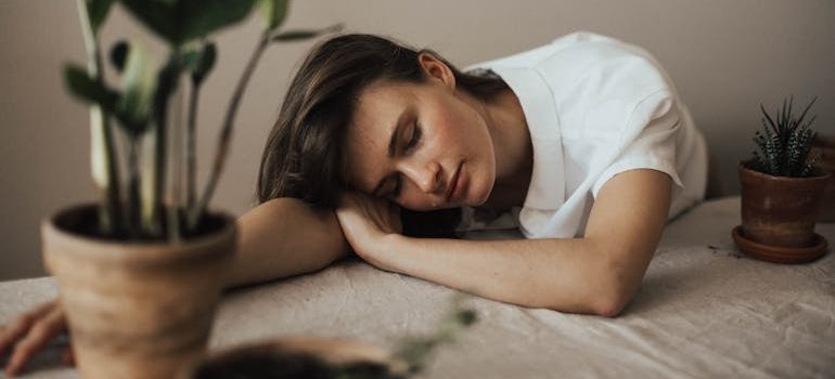 Уставшая женщина лежит на столе