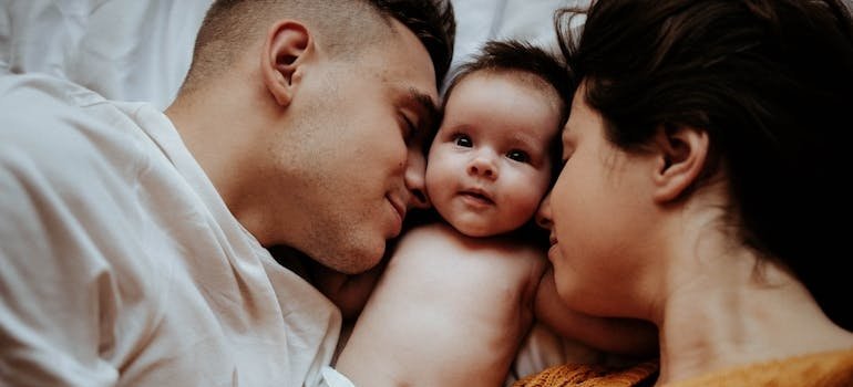 Родители лежат рядом с младенцем