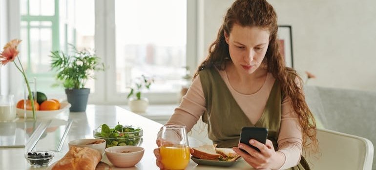 женщина ест и смотрит на телефоне, какие самые распространённые проблемы с желудком