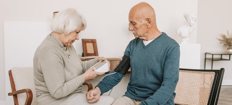 Женщина проверяет, не понижено ли у мужа артериальное давление.