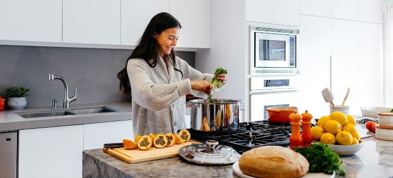 Женщина готовит блюдо, которое поможет восполнить дефицит магния