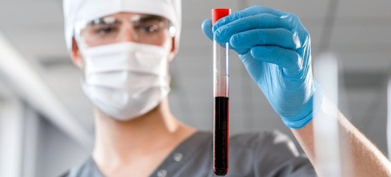 лабораторный техник держит образец крови для выявления синдрома XYY синдрома Джейкобса