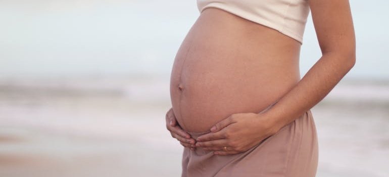 беременная женщина держится за живот